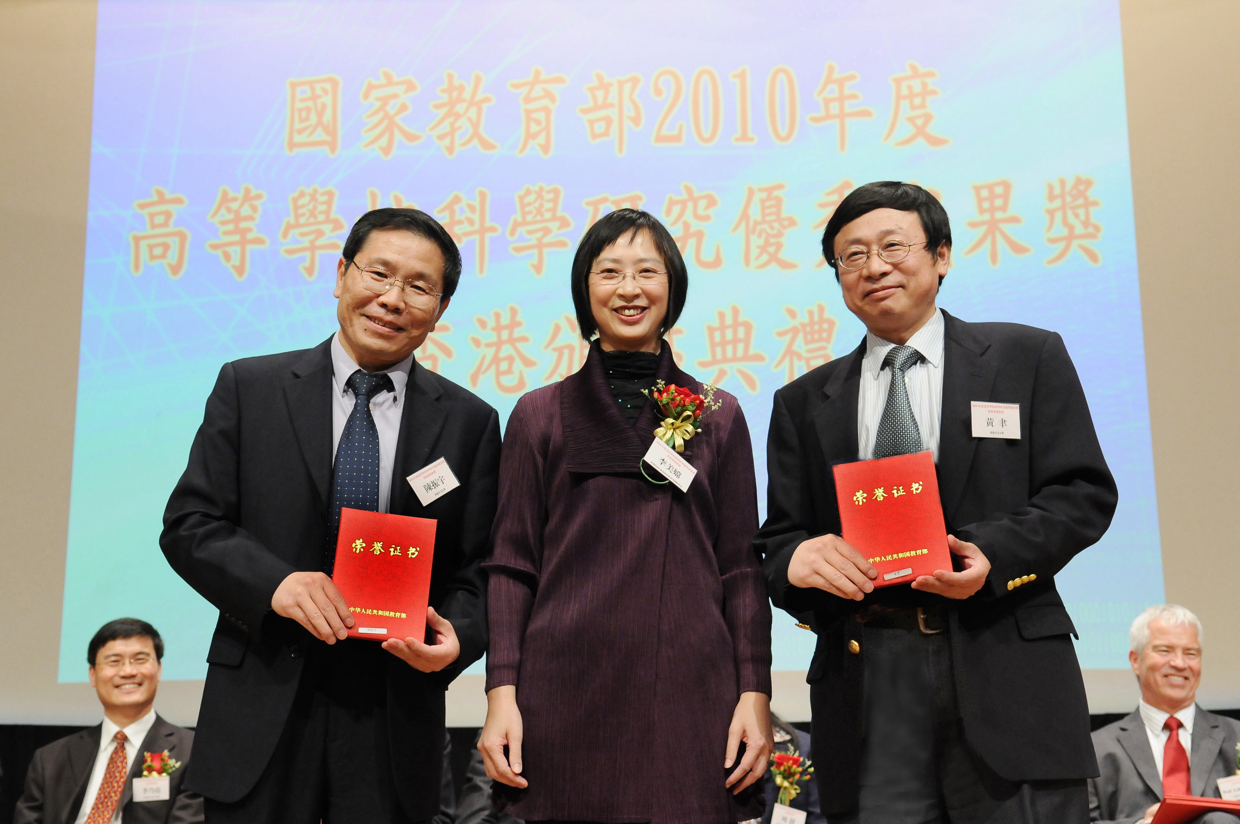 Prof. Zhenyu Chen (left) and Prof. Yu Huang (right) receive their award certificates from Ms. Li Mei Sheung, Michelle, Deputy Secretary for Education, HKSAR Government.