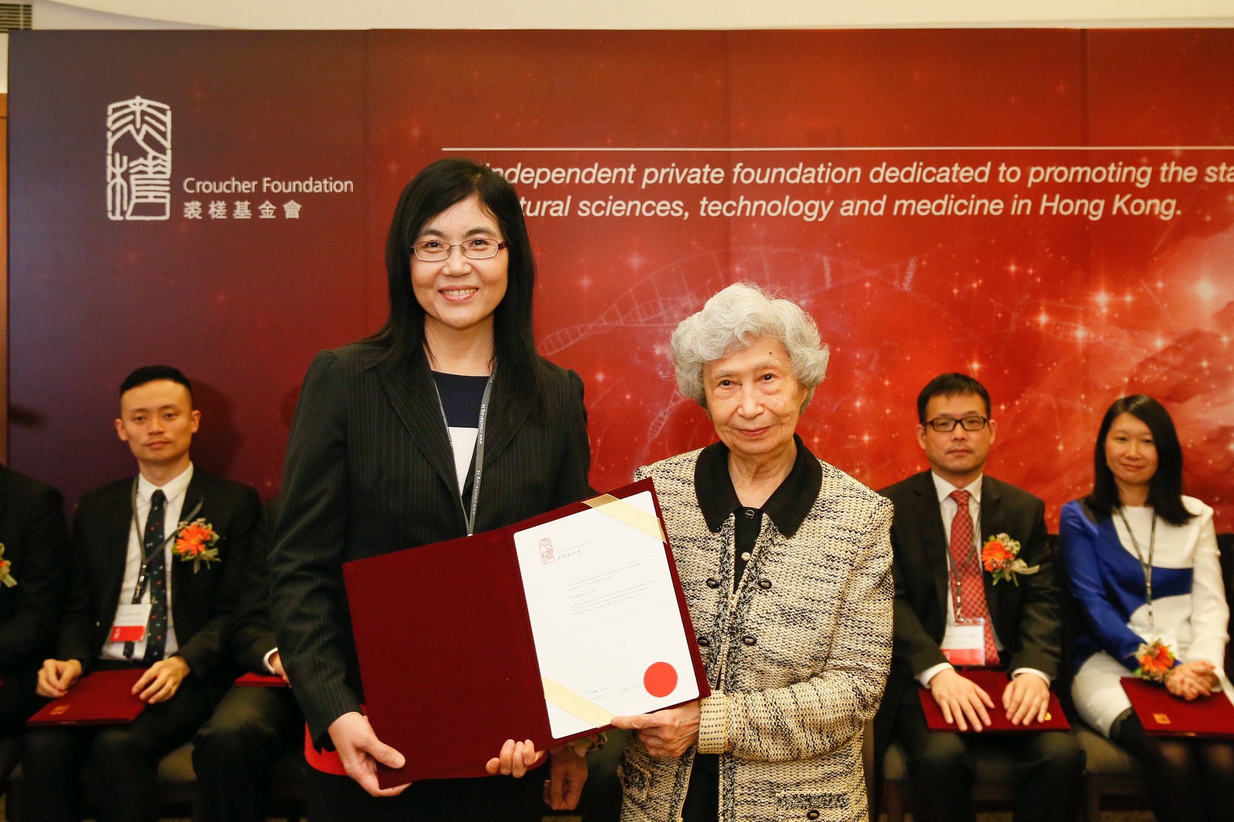 Prof Rosie Young presents the award of Senior Research Fellowship to Prof Jun Yu.