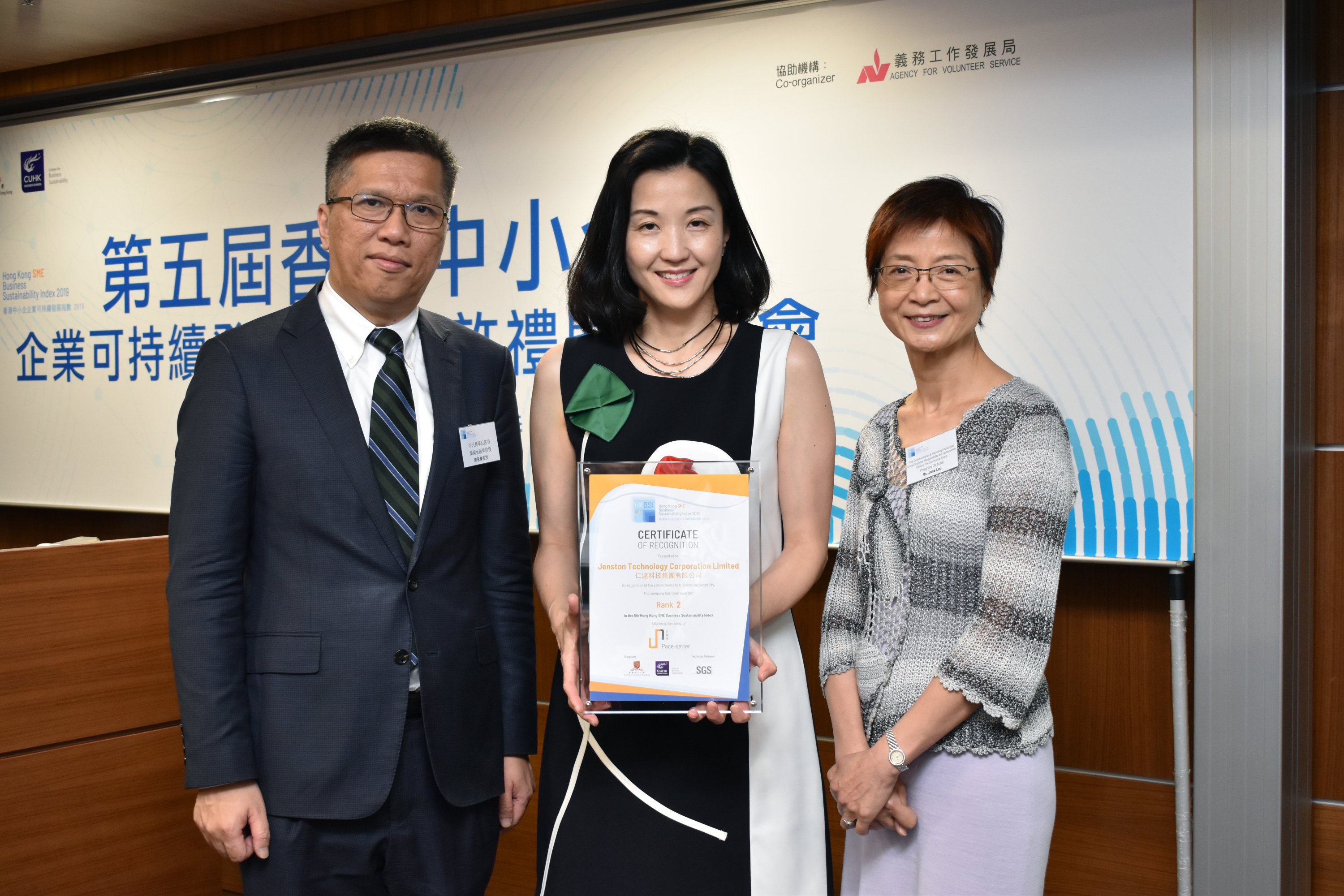 Prof. Kalok Chan, Dean of CUHK Business School and Wei Lun Professor of Finance (left) and Ms. Jane Lau, Program Director, Asia Communication and Marketing Council and China Corporate Responsibility and Sustainability Council of The Conference Board (right) presented a certificate of recognition to a representative from one of the top 10 HKSMEBSI SMEs.