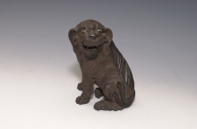 Unglazed Lion Dog
Early 20th century, attributed to Huo Jin
Shiwan kiln ware of Foshan, Guangdong province
Gift of Bei Shan Tang
Art museum collection
Acc. no. 1981.0065 
The Lion dog, also known as Pekingese, is a Chinese ancient breed of small toy dog. This unglazed lion dog came from the Shiwan kiln of Foshan, Guangdong province, whose body was made from the local red clay, with dark brown glaze painted in places like eyes and nose. The sculpture is livened up by its turning head, opening mouth, as well as the impressed fine coat of hair. An elliptical mark on the neck denotes that it is made by the hunchback potter Huo Jin of Shiwan during republic China.