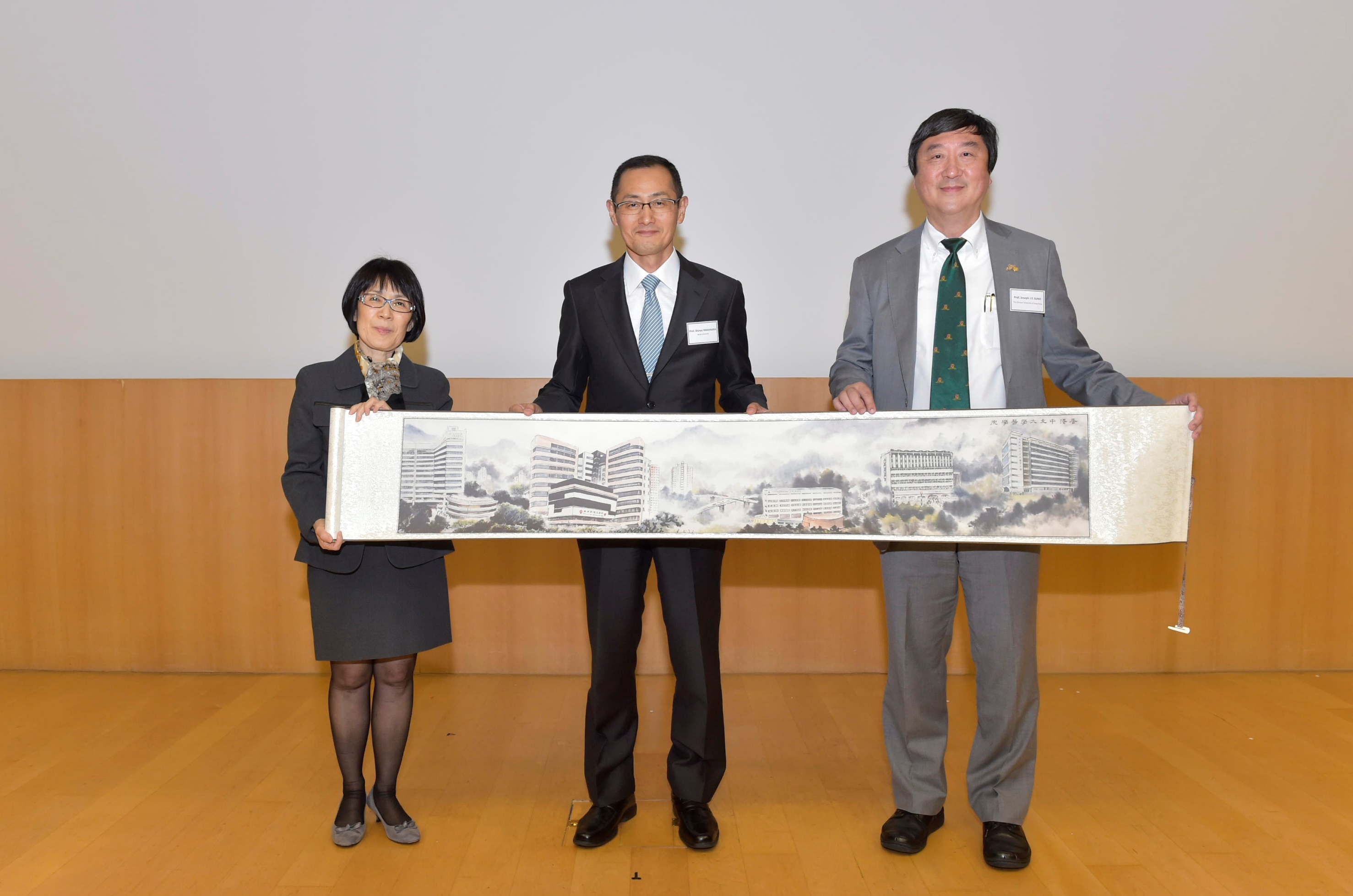 Prof. Joseph J.Y. Sung, Vice-Chancellor and President, CUHK (right) and Prof. Fanny M.C. Cheung, Pro-Vice-Chancellor and Vice-President, CUHK (left) present a souvenir to Prof. Shinya Yamanaka.