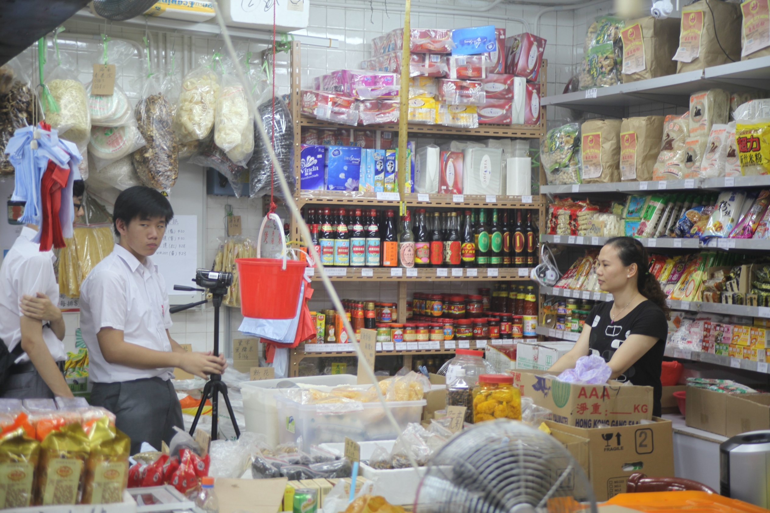 Two students interview a grocery shopkeeper at Tin Yiu Market.