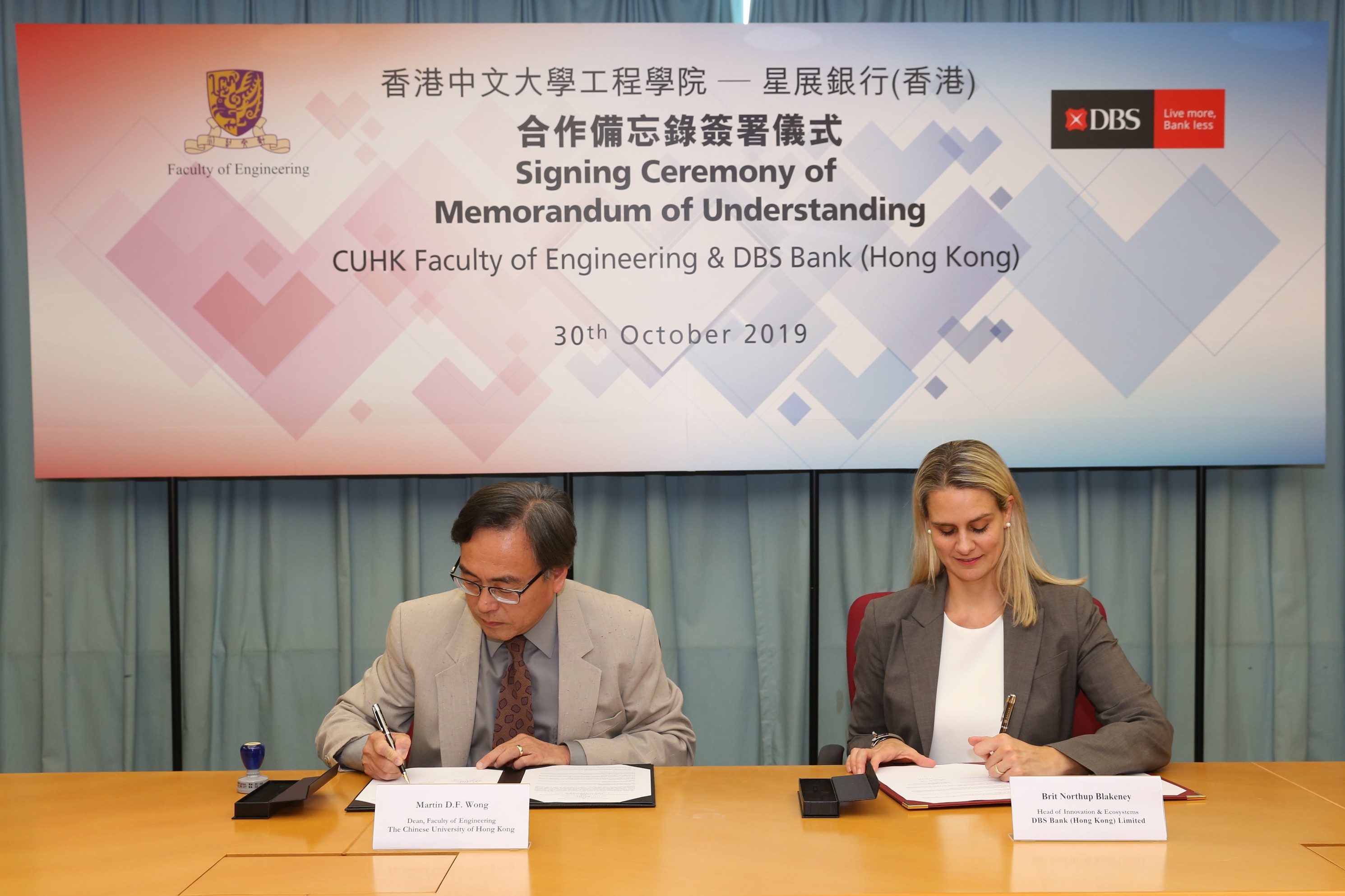 Professor Martin D. F. Wong, Dean of Engineering, CUHK (left) and Ms. Brit Blakeney, Head of Innovation & Ecosystems, DBS Hong Kong (right) sign a collaboration agreement.