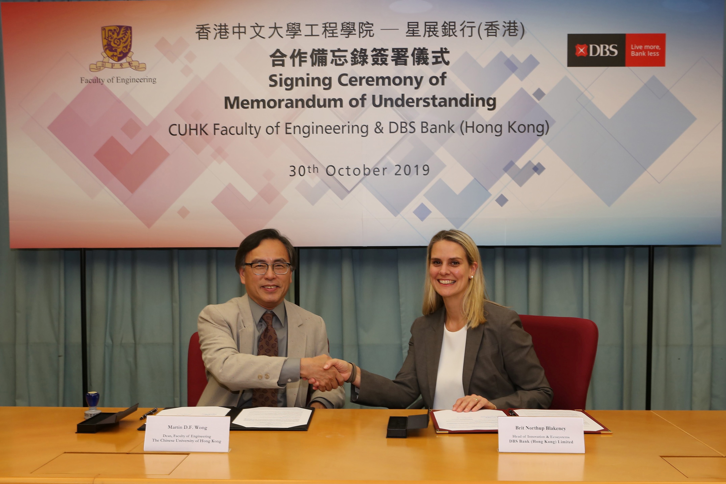 Professor Martin D. F. Wong, Dean of Engineering, CUHK (left) and Ms. Brit Blakeney, Head of Innovation & Ecosystems, DBS Hong Kong (right) sign a collaboration agreement.