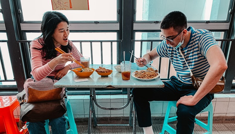 August (right) learns the art of using chopsticks from his local peers. 