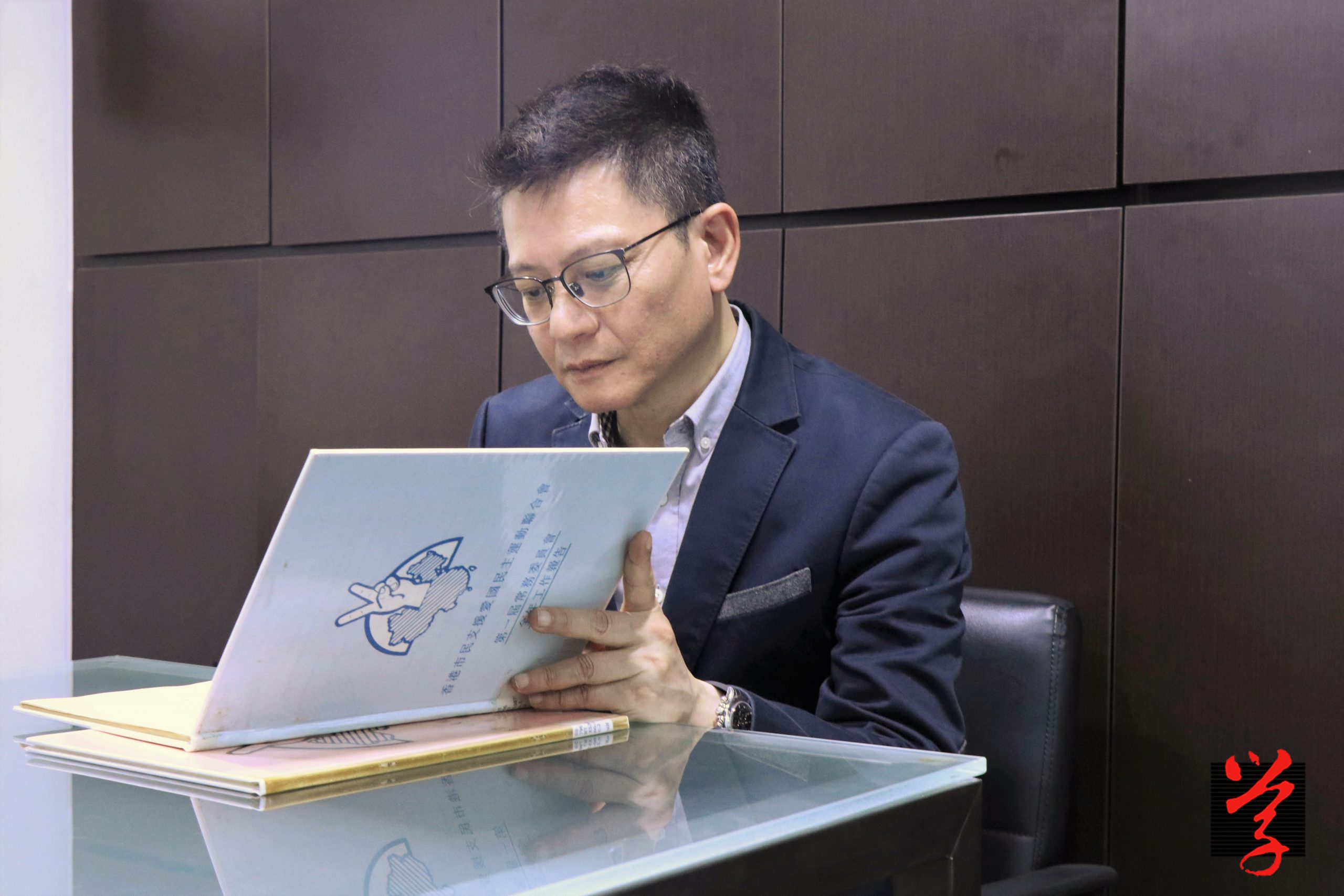 陶君行翻閱支聯會首屆工作報告,記得曾開會討論是否將「結束一黨專政」列作綱領 (趙泓達攝)