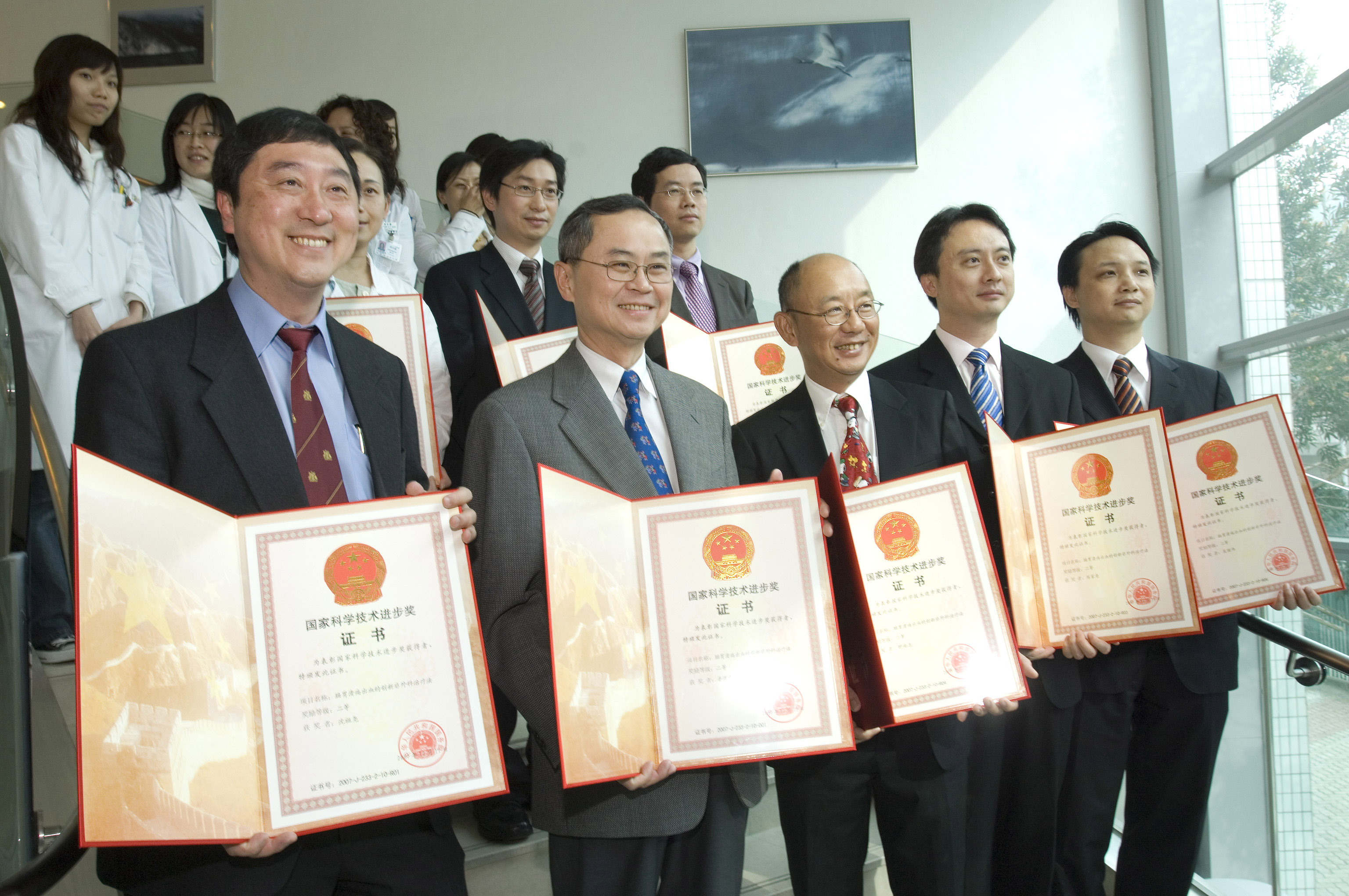 Prof Joseph Sung, Prof T.F. Fok, Prof Sydney Chung, Prof Francis Chan, Prof Enders Ng (front row from left to right)
Prof Philip Chiu (second row middle), Prof Y. T. Lee (second row right) and other members of the research team