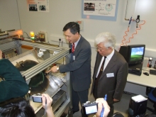 Professor Yam Yeung (left) introduces the functions of the intelligent grinding machine to Professor Zhou Liwei (right).