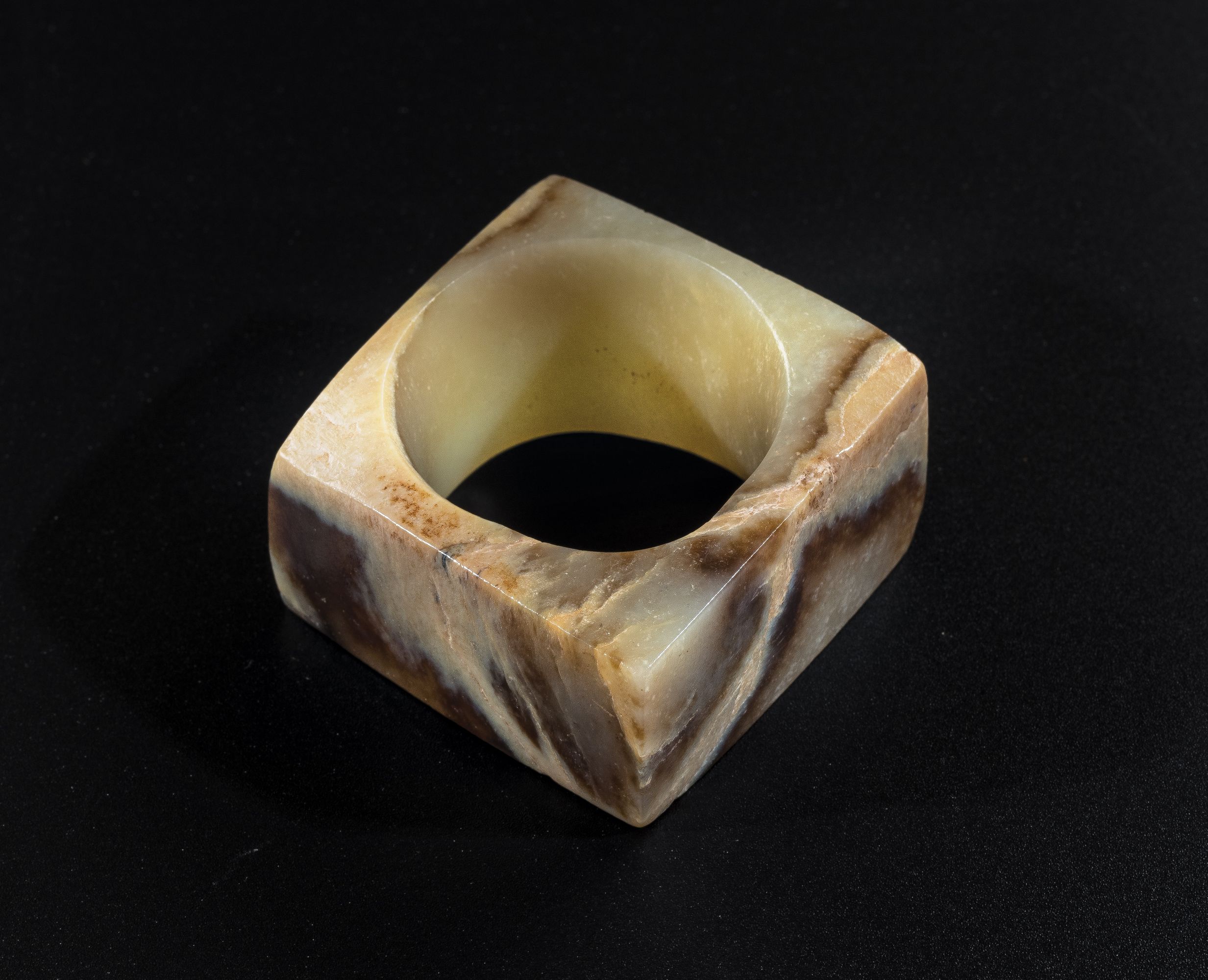 Jade cong
Acc. no. 2017.0072 
Pale green jade with caramel-coloured striations was common raw material of Qijia jades. Jade cong of Qijia culture had a large circular hole in the centre and thin walls with a slightly convex surface, unlike that of Liangzhu culture.