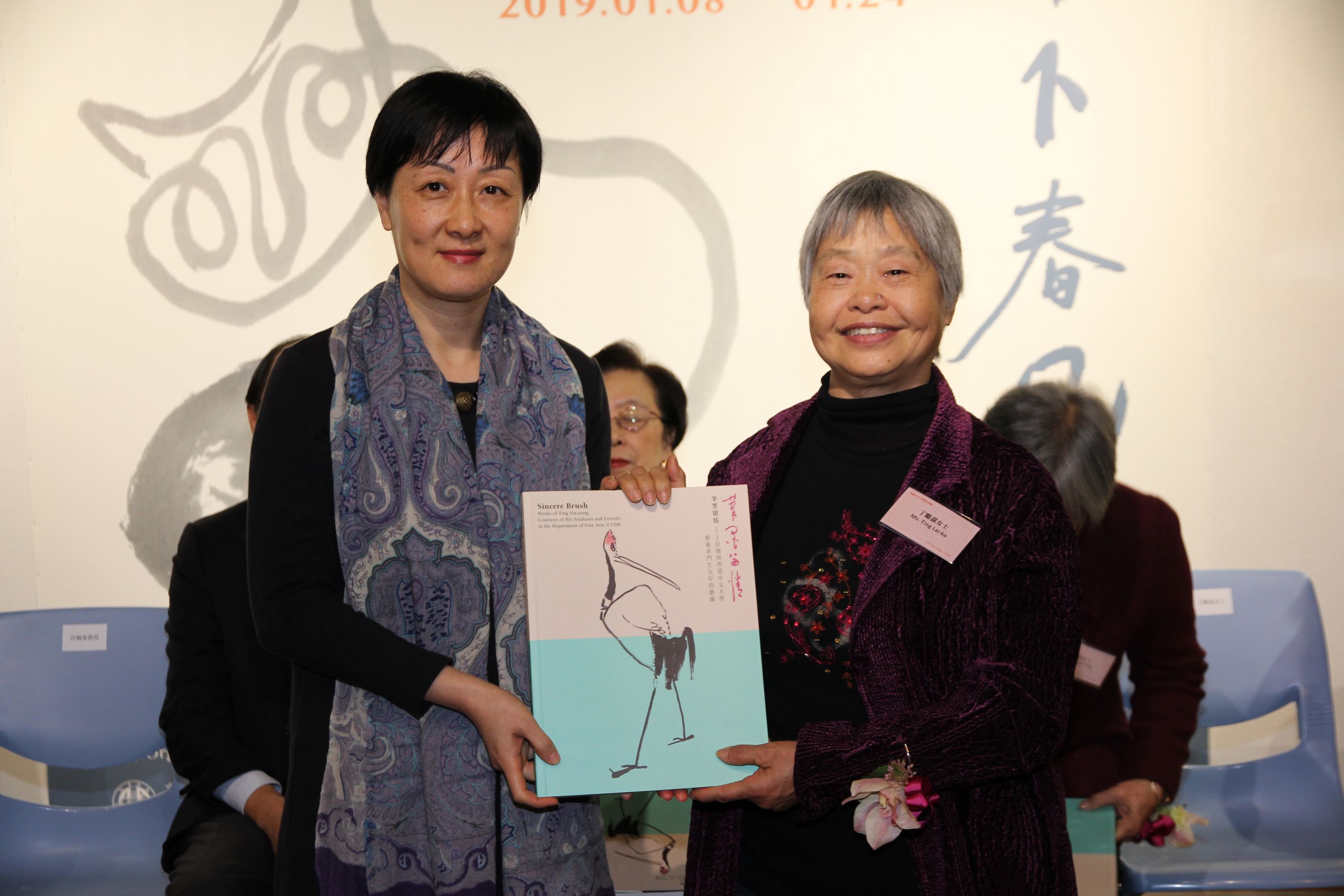 Prof. Xu Xiaodong, Associate Director of the Art Museum, CUHK presents a souvenir to Ting Lai-ka, a daughter of Ting Yin-yung.