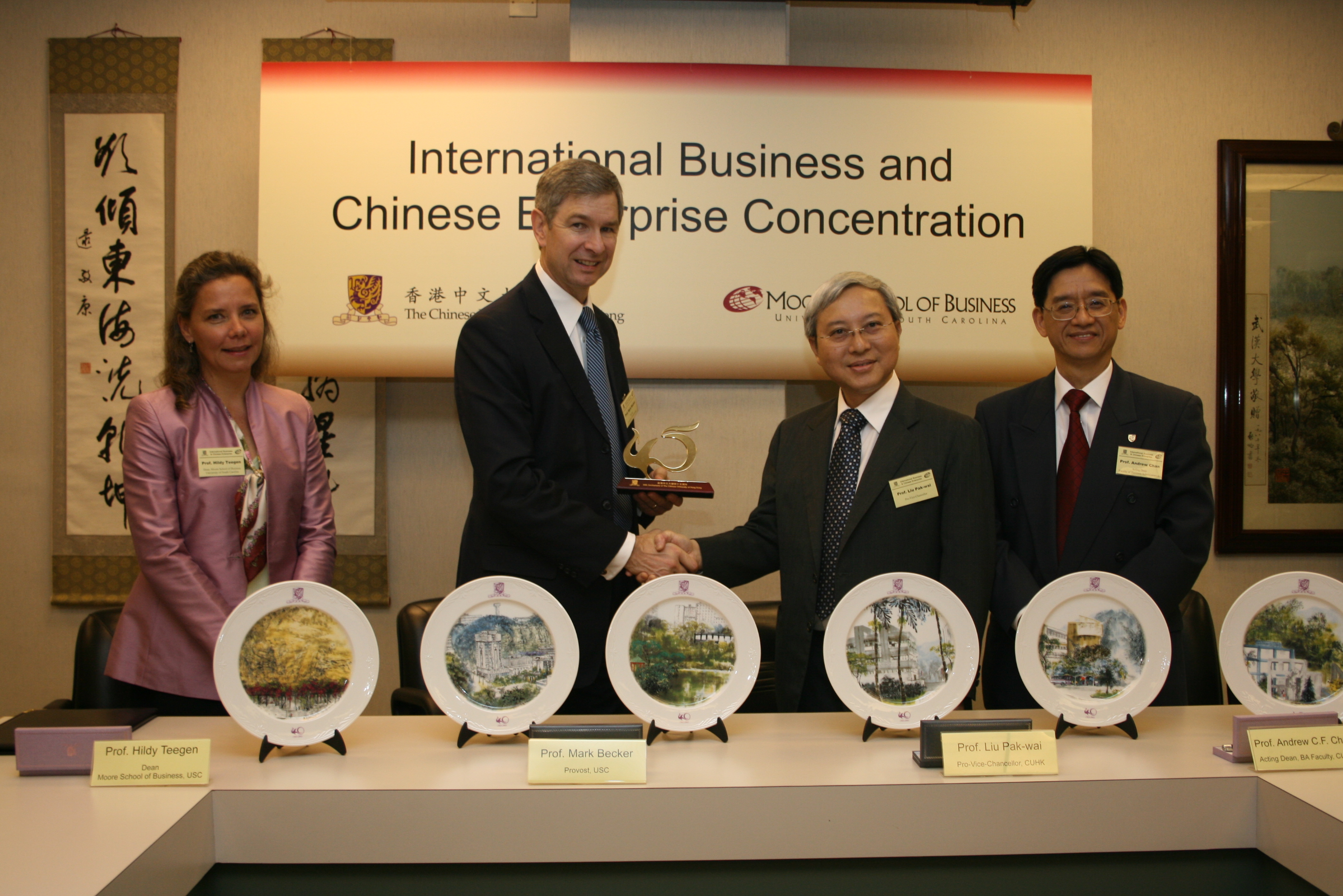 Prof. Prof. Liu Pak Wai, Pro-Vice-Chancellor of The Chinese University of Hong Kong (CUHK) presented CUHK 45th Anniversary souvenir to Prof. Mark Becker, Provost of the University of South Carolina. On the left is Prof. Hildy J. Teegen, Dean, Moore School of Business, University of South Carolina and on the right is Prof. Andrew Chan, Acting Dean, Faculty of Business Administration, CUHK.