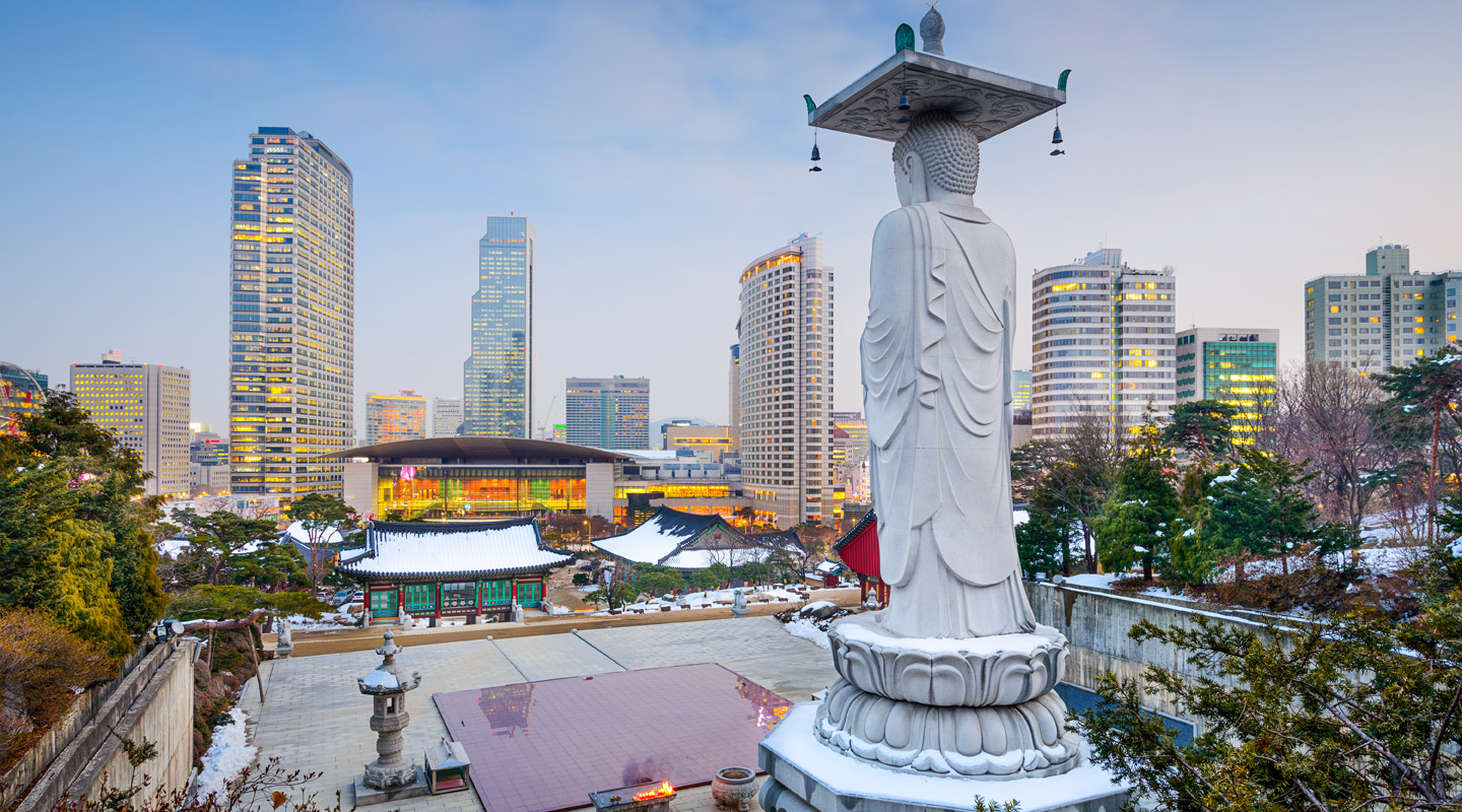 Gangnam district lights up for the night while the Buddha statue silently watches