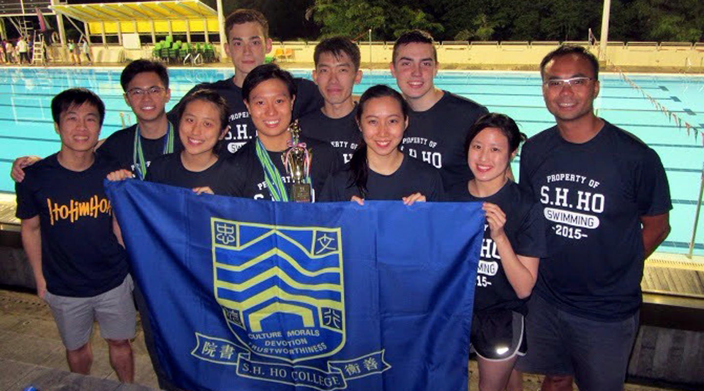 Rachel (holding the trophy) with swimming coach Mr. Clement Wu (1st right) and swimming team members of S.H. Ho College <em>(courtesy of Mr. Wu)</em>