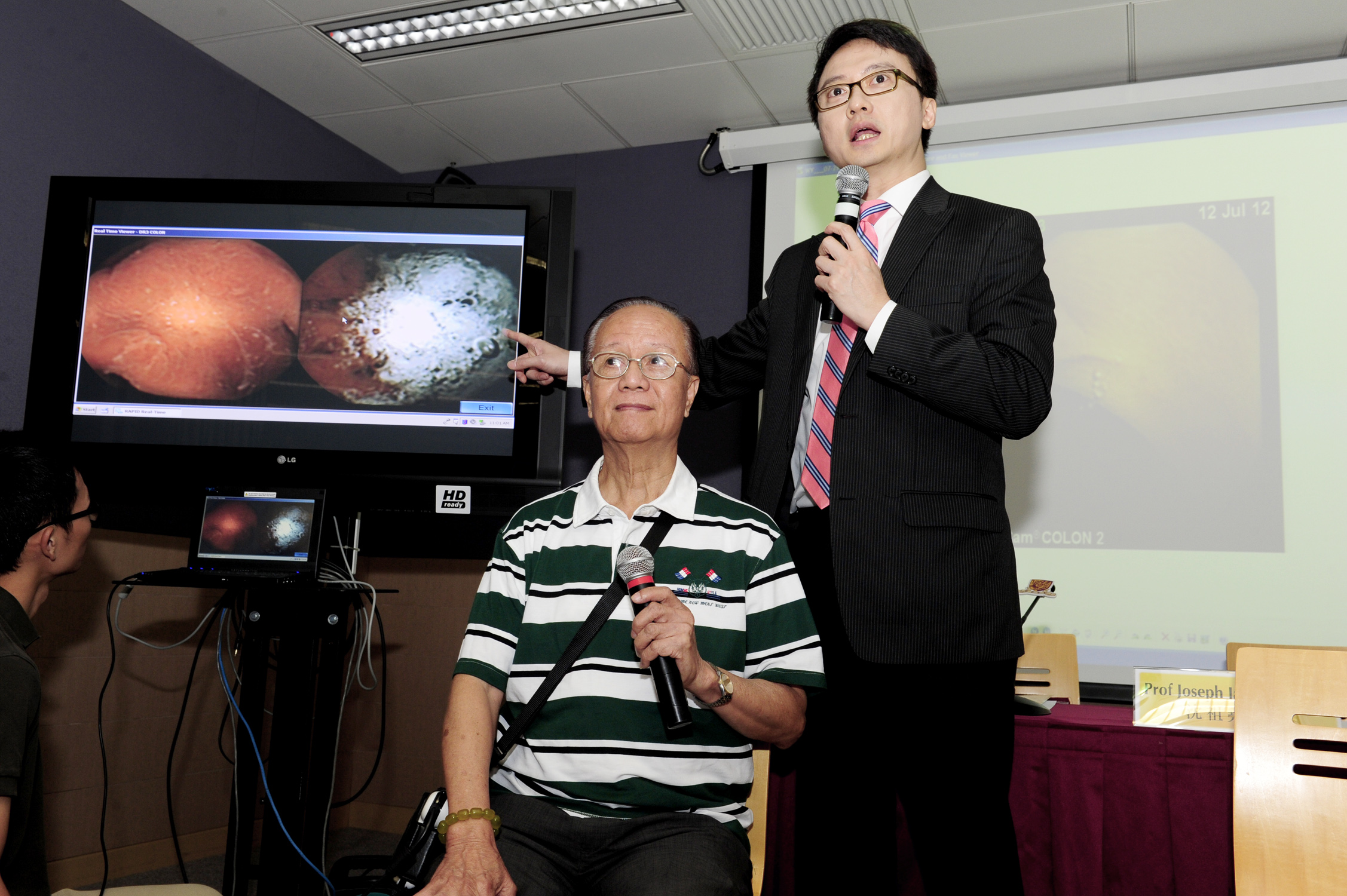 陳家亮教授(右)展示大腸膠囊內視鏡拍攝的實時影像