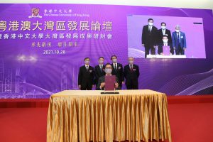 Professor Alan K.L. Chan (front row), Provost of CUHK and Mr. Wang Jinxia (on the screen), Deputy Director General of the Authority of Qianhai Shenzhen-Hong Kong Modern Service Industry Cooperation Zone sign the MoU regarding the framework agreement on strategic cooperation.