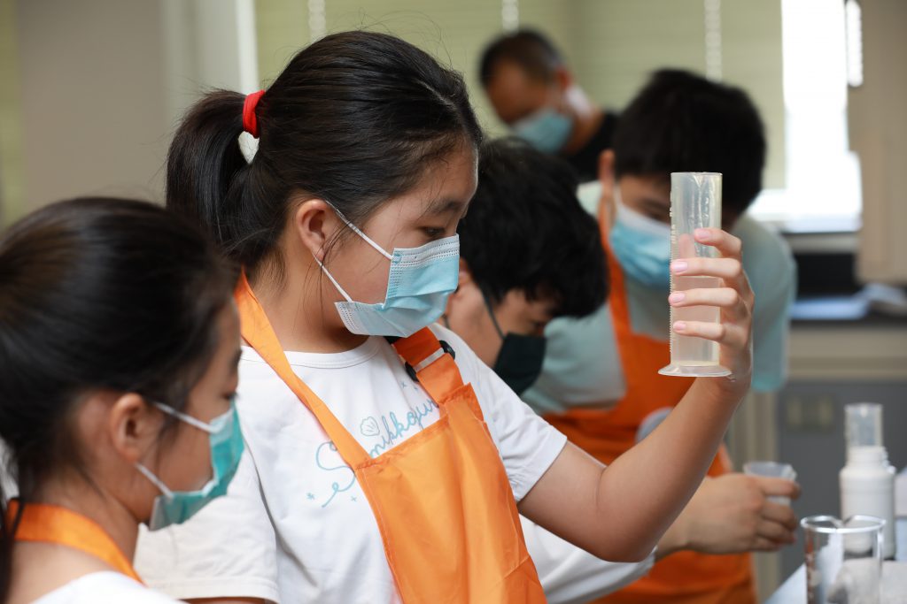 A student carefully measuring the ingredients of the hand sanitiser