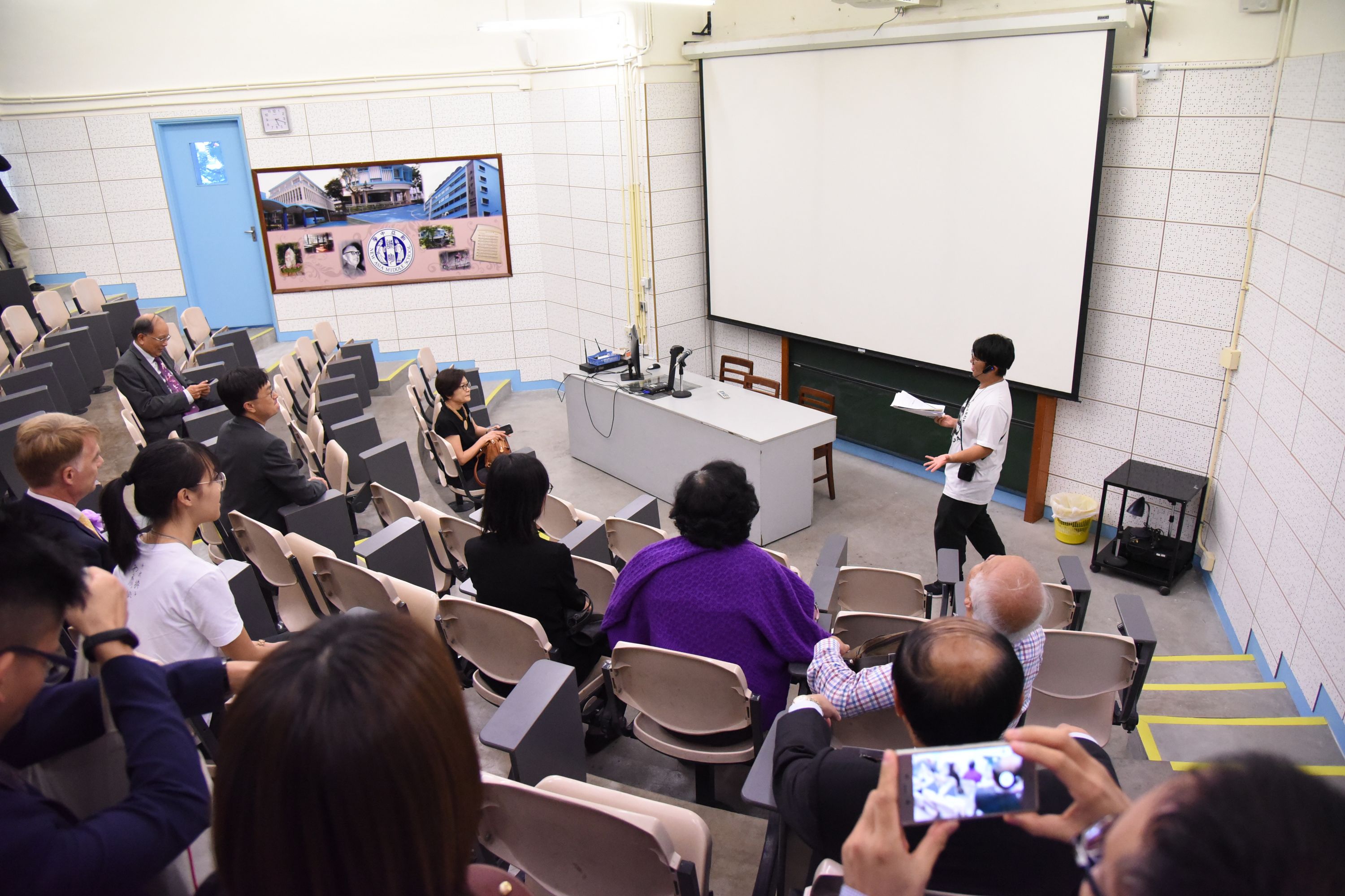 New Asia Young Scholar leads a guided-tour, picture shows the lecture theatre in New Asia Middle School.