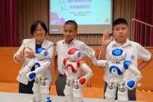 Prof. So Wing-chee and two students of Hong Chi Morninghill School, Tsui Lam demonstrate various gestures with the social robots.