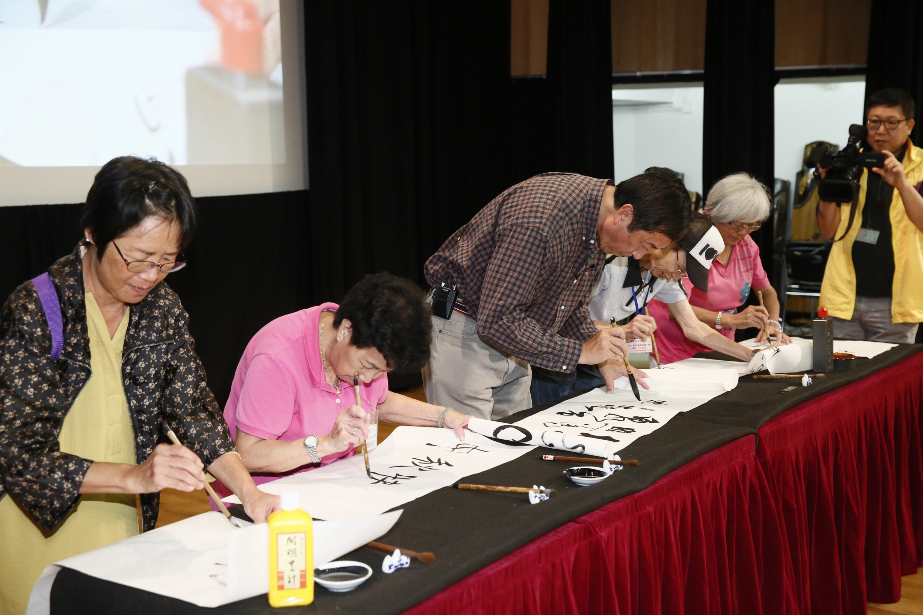 Prof. Sung (Middle) demonstrates Chinese calligraphy with the elderly.