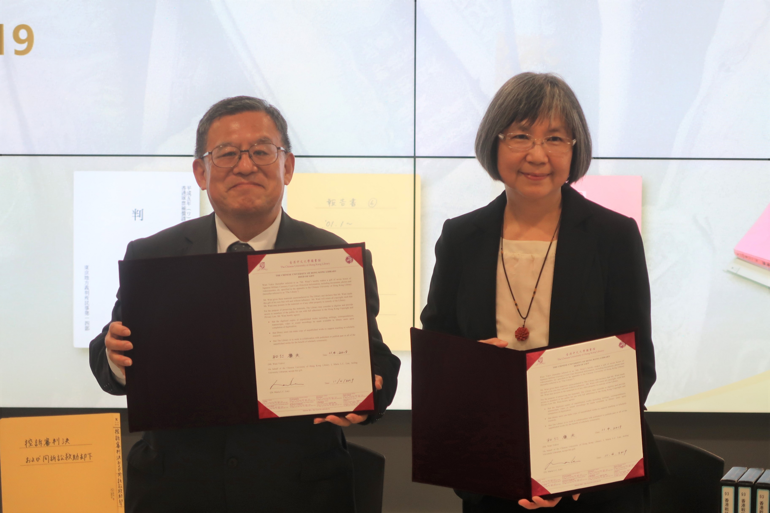 Mr. Wani Yukio and Dr. Maria Lau sign the donation papers.