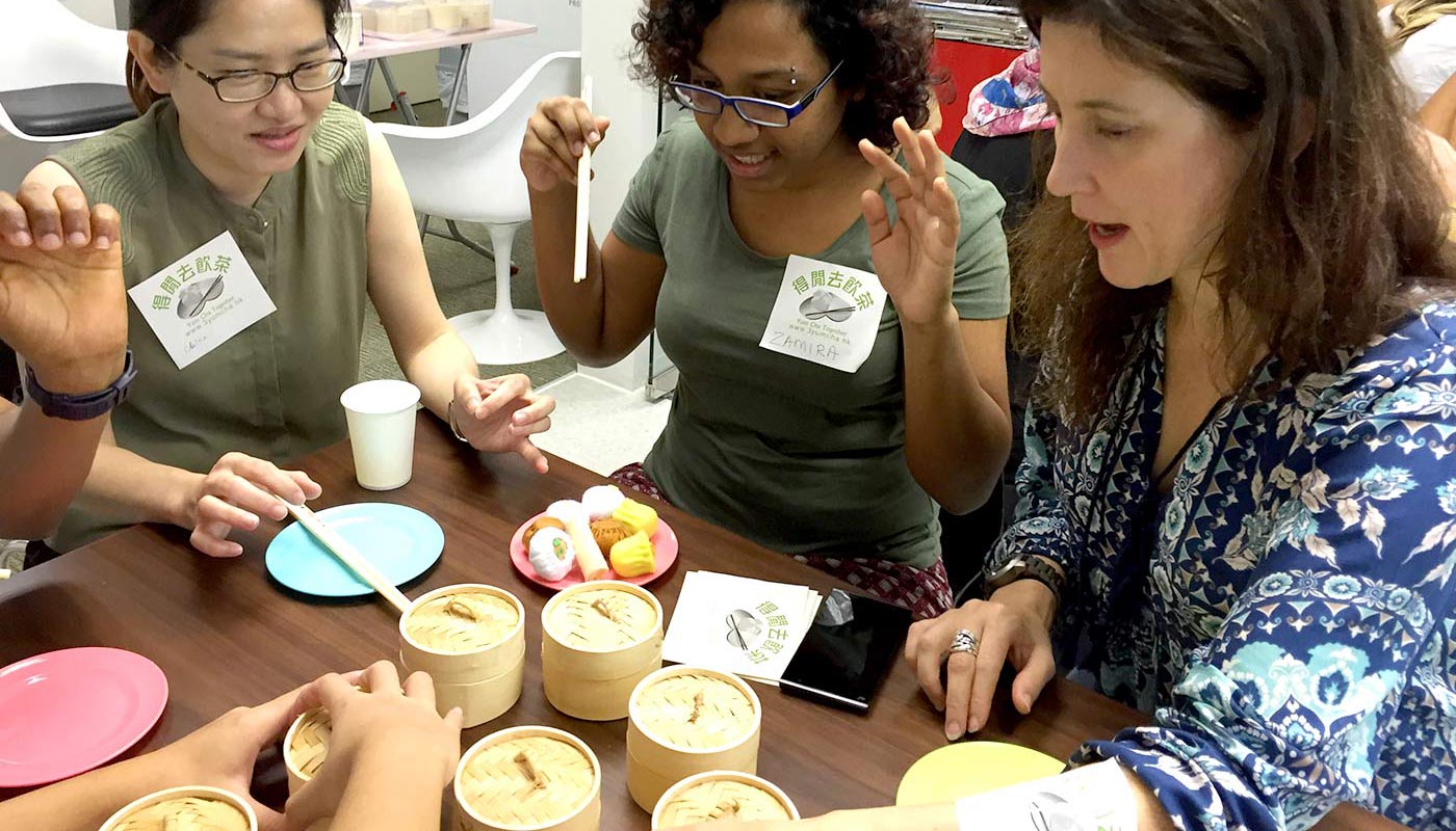 Shaw College’s international students practicing yum cha etiquettes with mock dim sum