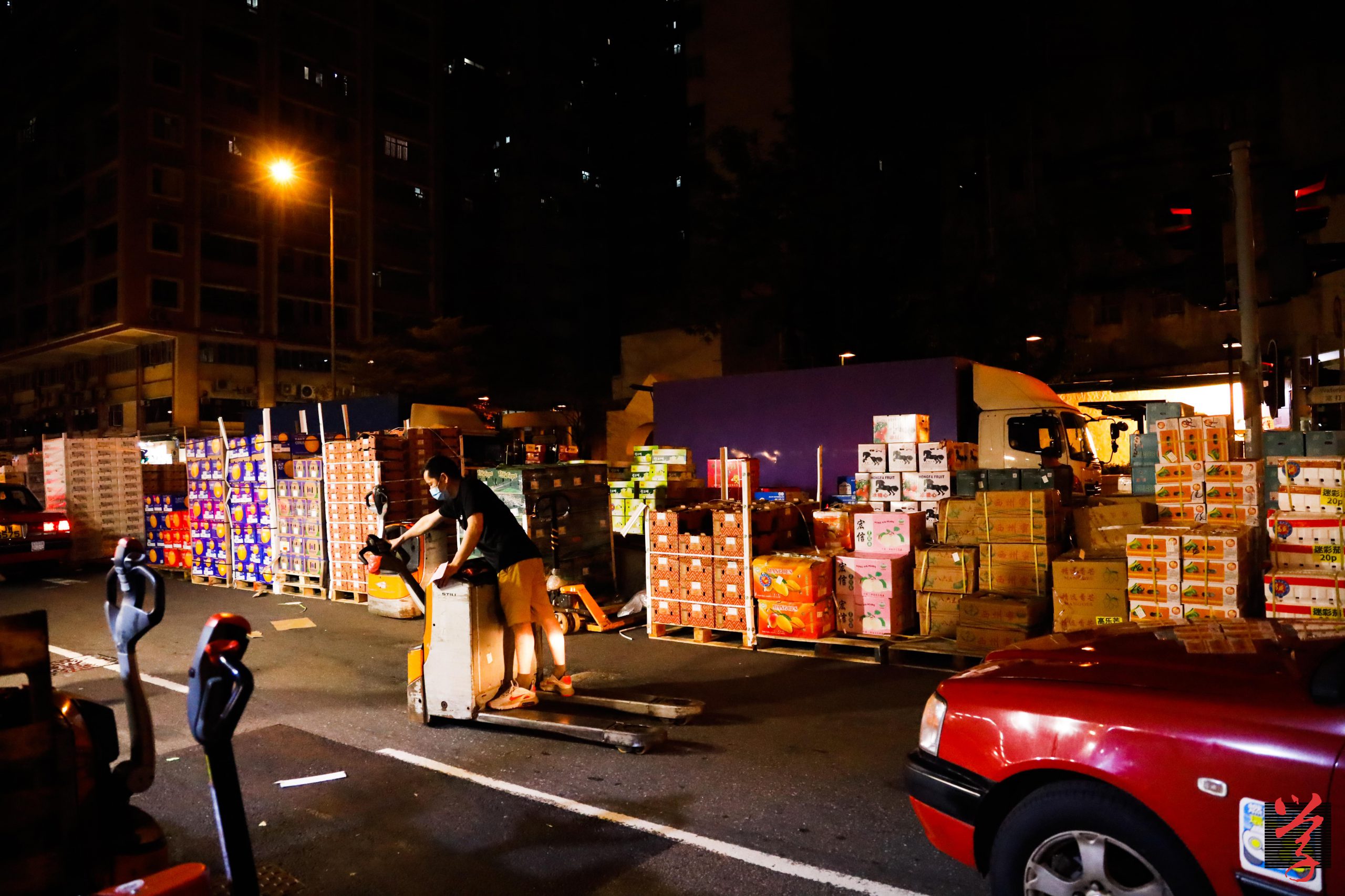 果欄工人在如此擠逼的地方用電動唧車代步，於馬路和大街小巷上奔馳。