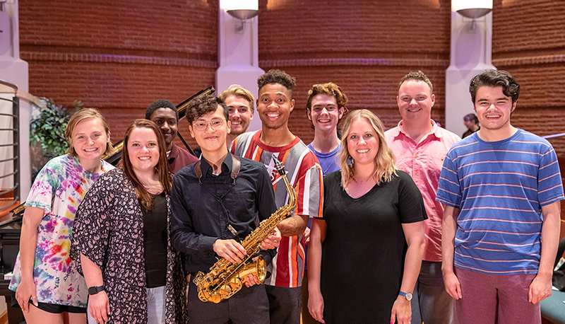 Lok Sam is supported by his friends during his saxophone performance. 