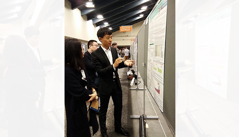 Dr. MENG Fanbao (right) presents his research work on rock mechanics to the meeting participants.