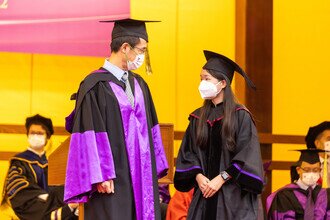 Graduates being blessed and congratulated by Faculty member on stage