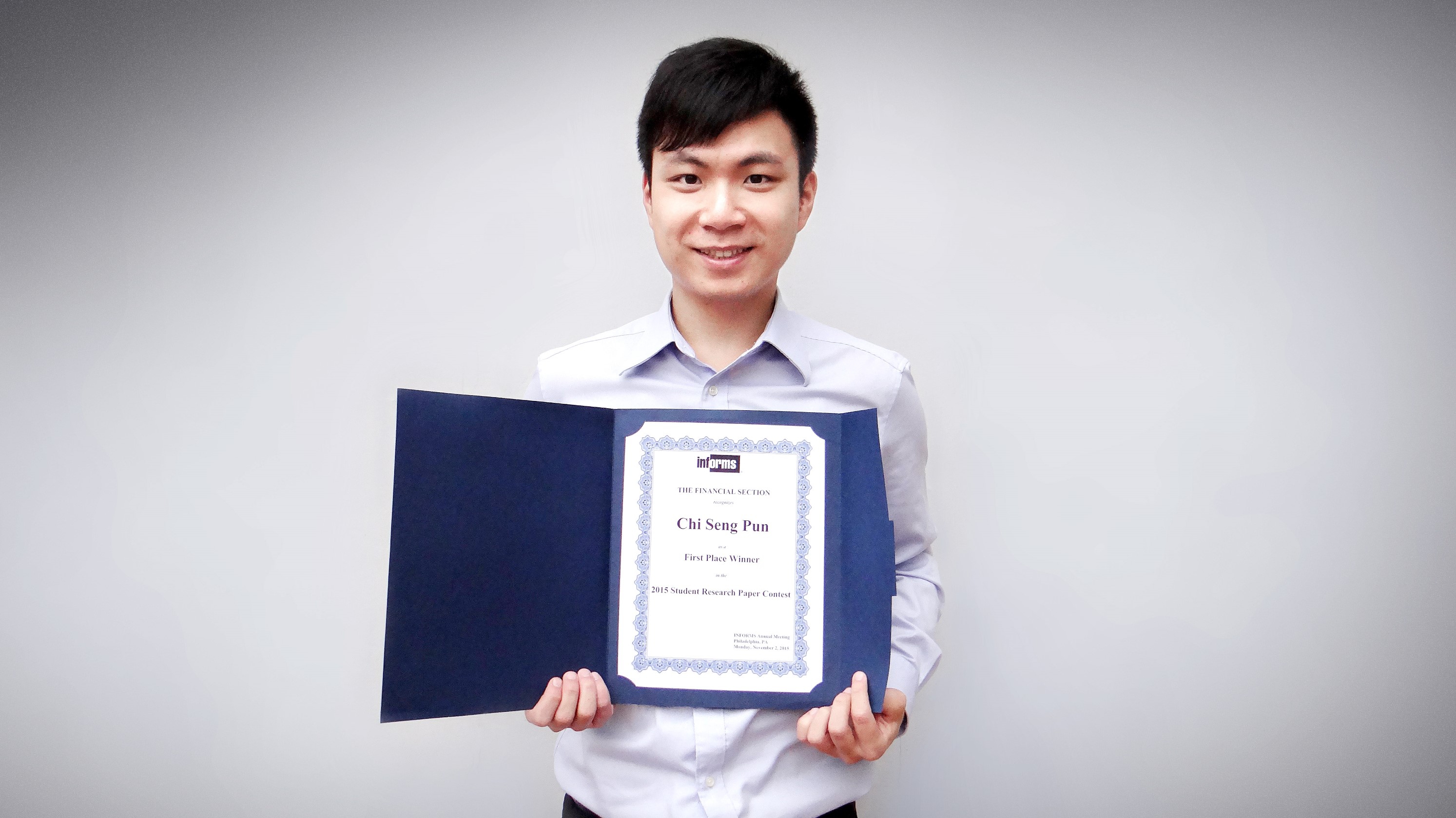 Pun Chi-seng shows his award certificate for his research paper “Combined Estimation-Optimization (CEO) Approach for High Dimensional Portfolio Selection”.