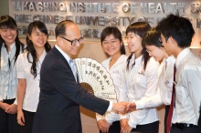 Dr Li Ka-shing receives a paper fan with an inscription “Knowledge reshapes destiny, scientific research constructs people’s livelihood” from a group of medical students of CUHK.