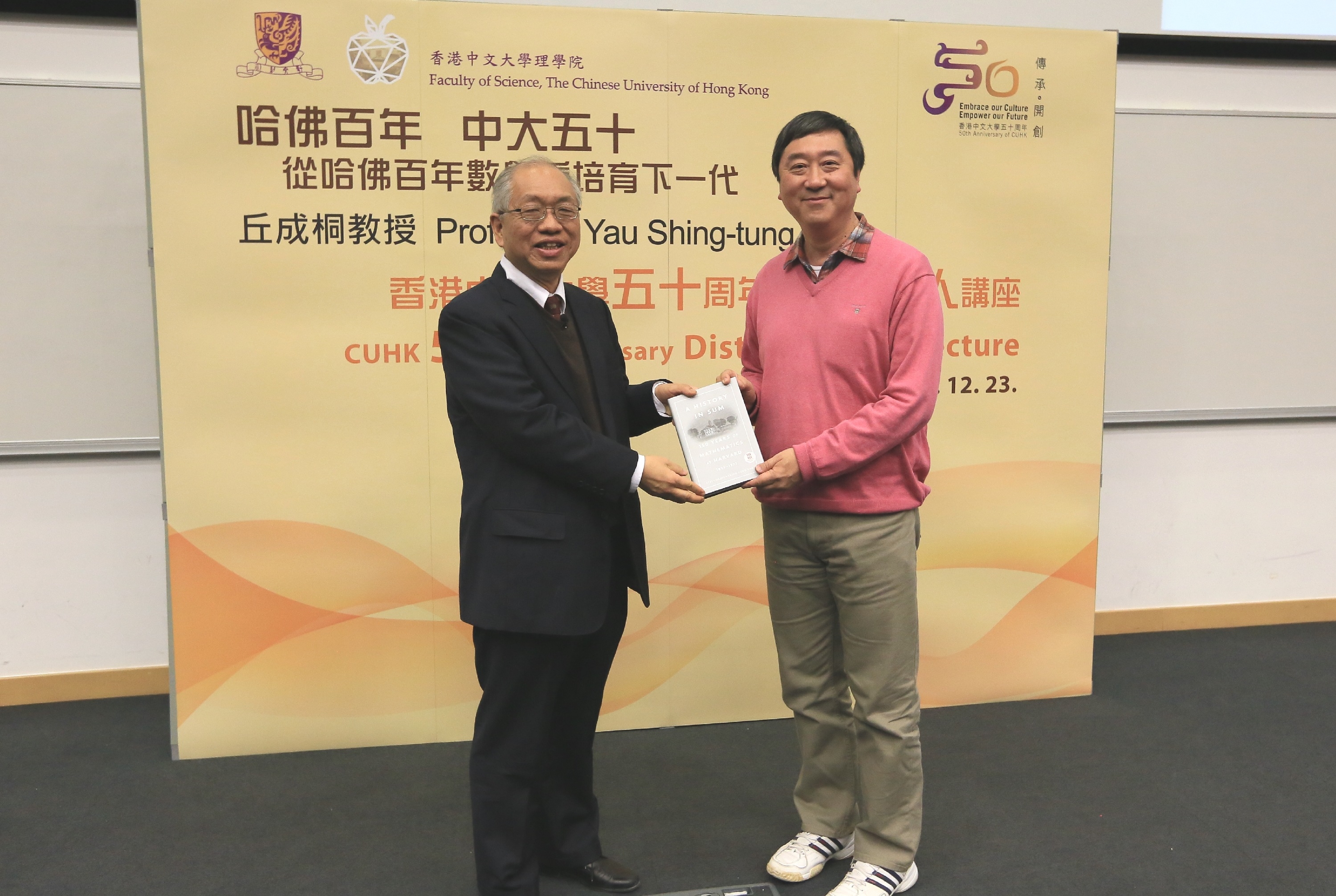 Prof. Yau Shing-tung presents his book on the history of the Mathematics Department of Harvard to Prof. Joseph Sung.