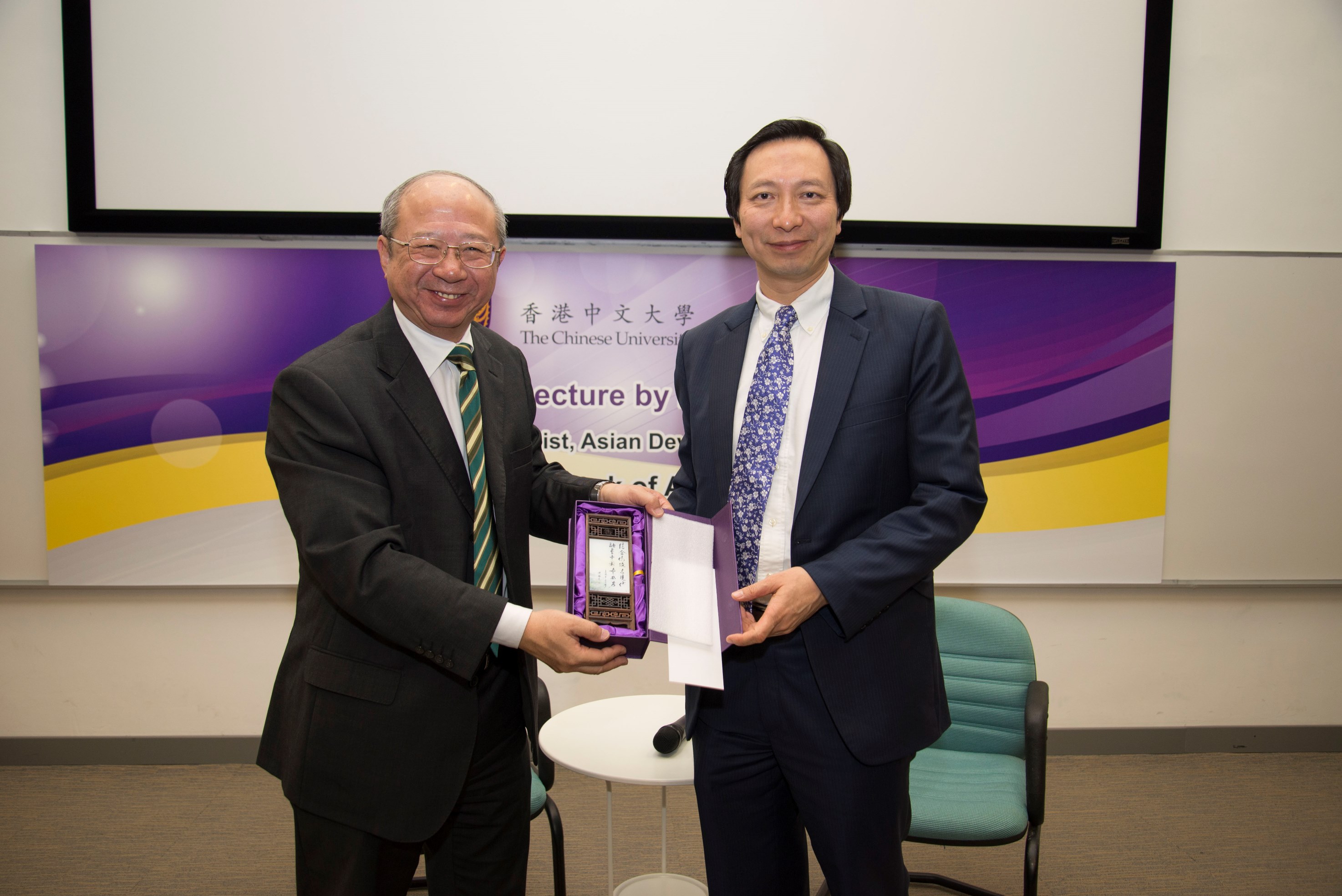 Prof. Michael Hui, Pro-Vice-Chancellor of CUHK (left) presents a souvenir to Dr. Shang-Jin Wei.