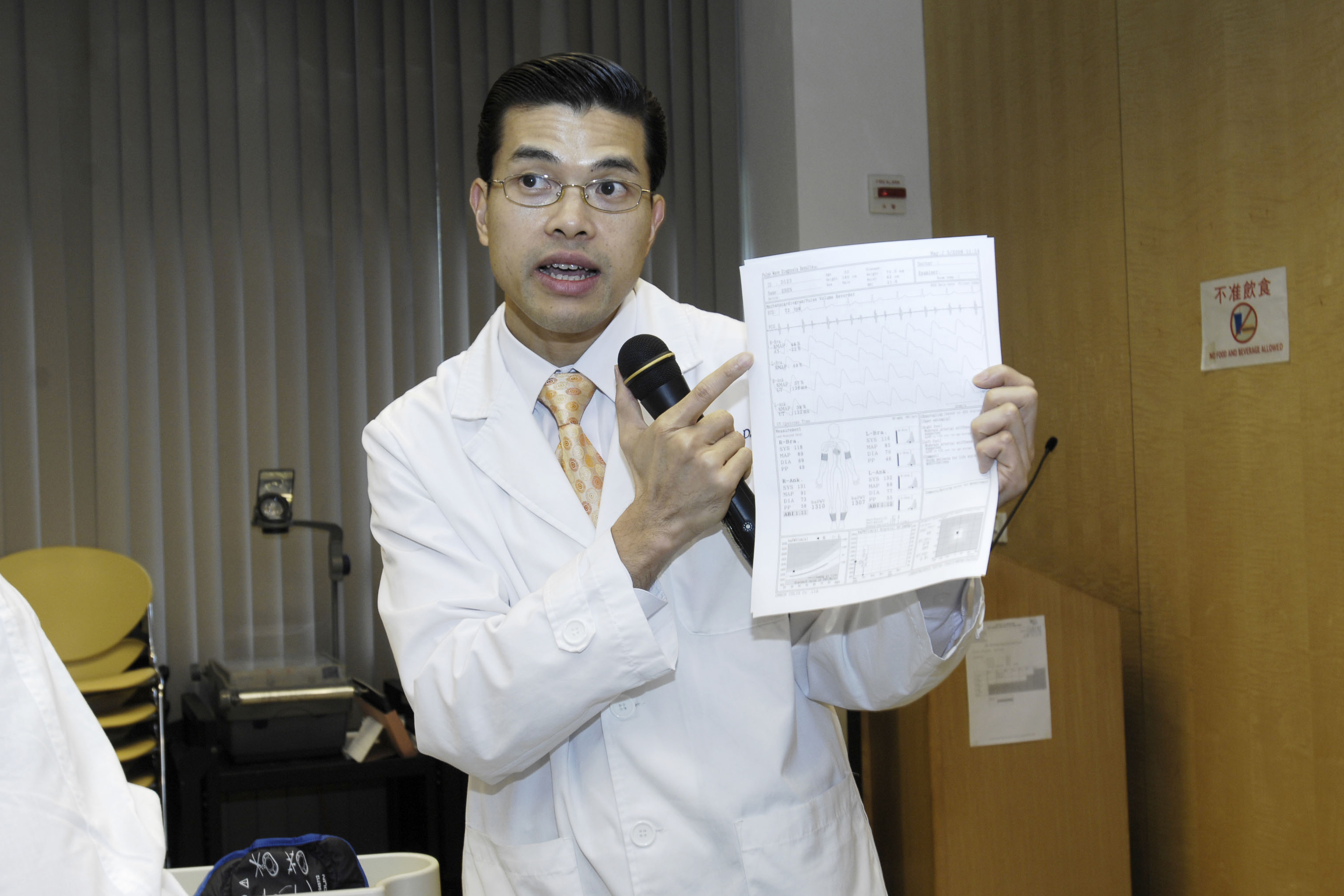 Professor Cheuk-Man Yu shows the report of the vessel stiffness test.